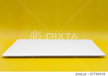 A rectangle empty white plate isolated on the yellow background. A rectangle empty white plate isolated on the yellow background. 67789456