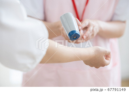 医療 非接触体温計で検温する看護師(手元) 医療 非接触体温計で検温する看護師(手元) 67791149