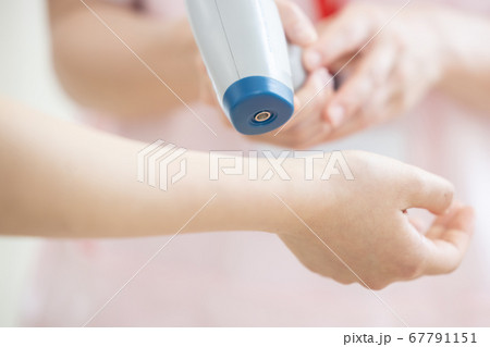 医療 非接触体温計で検温する看護師(手元) 医療 非接触体温計で検温する看護師(手元) 67791151