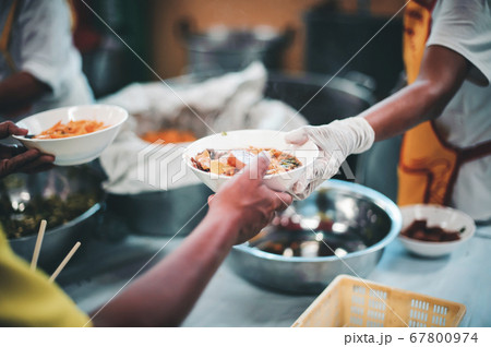 Volunteers give food to needy people, share food 67800974