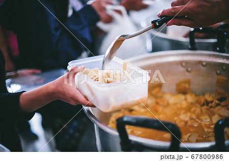Volunteers give food to needy people, share food 67800986