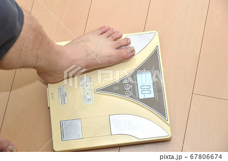 シニアの男性が体重計にのる様子・足 67806674