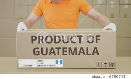 Warehouse worker and big box with PRODUCT OF GUATEMALA printed text Warehouse worker and big box with PRODUCT OF GUATEMALA printed text 67807434