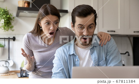 Amazed couple shocked by unexpected sale offer on laptop Amazed couple shocked by unexpected sale offer on laptop 67811384