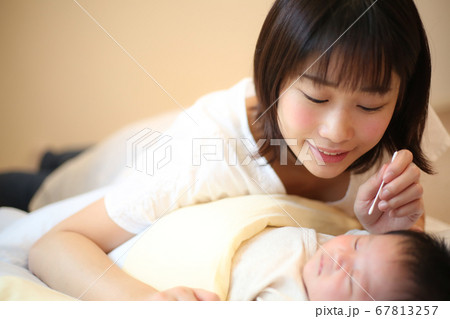 赤ちゃんの耳掃除をする母親の写真素材 赤ちゃんの耳掃除をする母親の写真素材