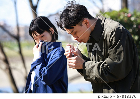 タバコを吸う男性と嫌がる女性 67813376