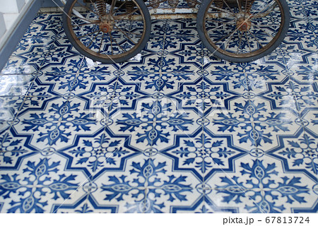 美しい模様の青いタイルの床とアンティークの乳母車の車輪の写真素材