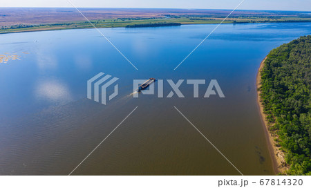 A barge or dry cargo ship goes upstream of the Volga River near Astrakhan. Aerial photography A barge or dry cargo ship goes upstream of the Volga River near Astrakhan. Aerial photography 67814320