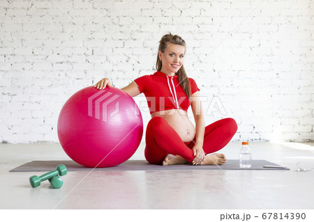 Smiling pregnant young woman with a fit ball. Smiling pregnant young woman with a fit ball. 67814390