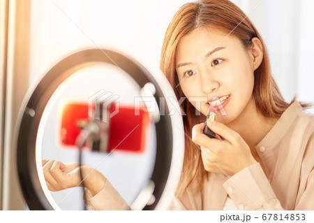 スマホカメラの前で化粧をする若い女性 スマホカメラの前で化粧をする若い女性 67814853