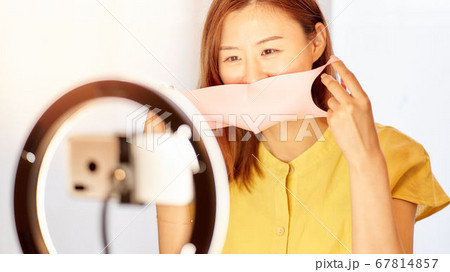 スマホカメラの前でマスクをつける若い女性 スマホカメラの前でマスクをつける若い女性 67814857