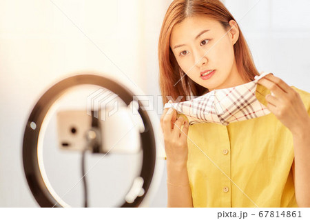 スマホカメラの前でマスクをつける若い女性 スマホカメラの前でマスクをつける若い女性 67814861