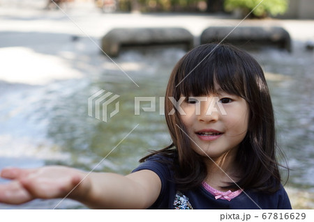 水遊びに誘う女の子の写真素材