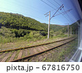 view from the window of a train car passing amidst summer nature with hills, mountains and forest. Vacation and travel concept. 67816750
