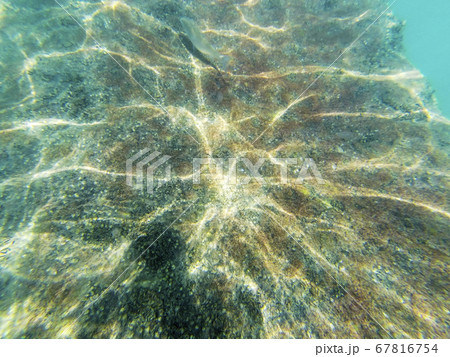Concrete block under water. Reflection of sun rays under water on a stone. 67816754