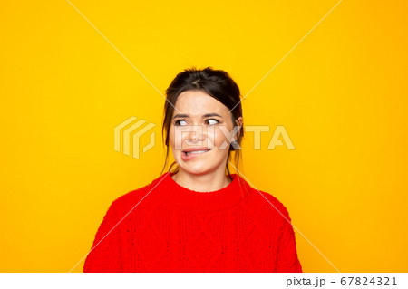 Woman in sweater wish something standing in the yellow studio isolated. Woman in sweater wish something standing in the yellow studio isolated. 67824321