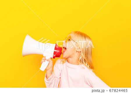 Kid shouting through vintage megaphone. Communication concept. Blue sky background as copy space for your text Kid shouting through vintage megaphone. Communication concept. Blue sky background as copy space for your text 67824465