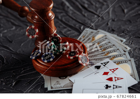 Legal rules for online gambling concept. Wooden gavel and playing cards on grey background Legal rules for online gambling concept. Wooden gavel and playing cards on grey background 67824661