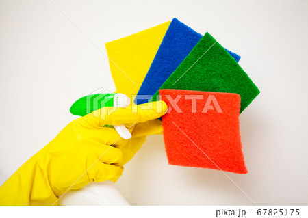 Closeup of hand in yellow mittens holding cleaning supplies. Closeup of hand in yellow mittens holding cleaning supplies. 67825175