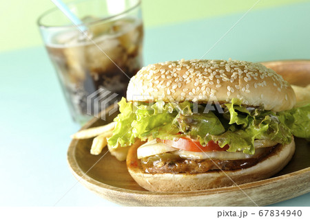 2色の背景紙を使って撮影した丸い木皿の上の照り焼きバーガーとポテトフライそしてコーラ 2色の背景紙を使って撮影した丸い木皿の上の照り焼きバーガーとポテトフライそしてコーラ 67834940