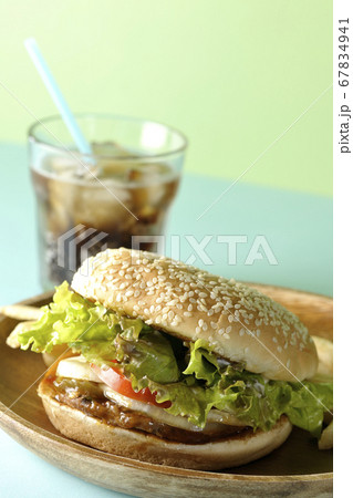 2色の背景紙を使って撮影した丸い木皿の上の照り焼きバーガーとポテトフライそしてコーラ 2色の背景紙を使って撮影した丸い木皿の上の照り焼きバーガーとポテトフライそしてコーラ 67834941