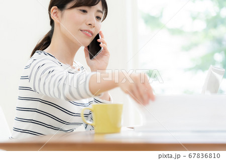 スマホで通話する女性【テレワーク】 67836810