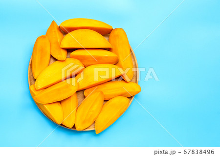 Tropical fruit, Mango slices on wooden plate Tropical fruit, Mango slices on wooden plate 67838496