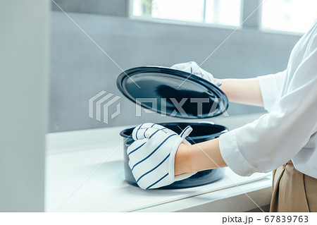 明るい白いキッチンでミトンをつけて黒い鍋の蓋を開ける kitchen pot mitten 明るい白いキッチンでミトンをつけて黒い鍋の蓋を開ける kitchen pot mitten 67839763