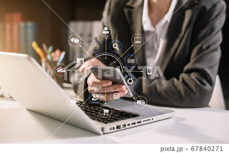Businesswomen hand using smart phone, tablet payments online shopping, omni channel, digital tablet docking keyboard computer at office in sun light. 67840271