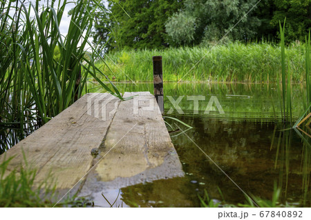 Old rustic wooden jetty on a tranquil lake 67840892