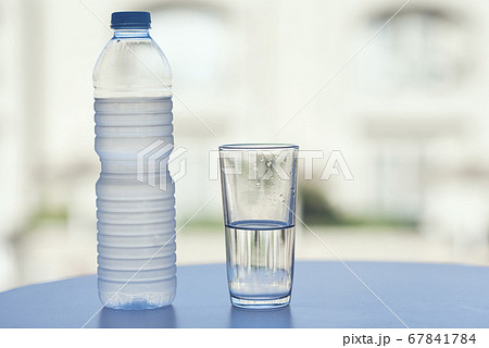 Bottle of water and glass of water on table in hot 67841784