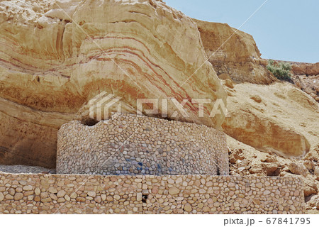 Rock with a soil layers against blue sky 67841795