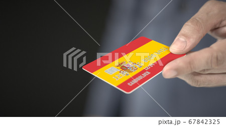 Man offers plastic bank card with printed flag of Spain, close-up shot. Fictional numbers Man offers plastic bank card with printed flag of Spain, close-up shot. Fictional numbers 67842325