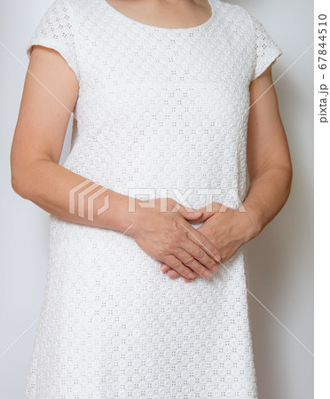 お腹に手を当てる女性 67844510