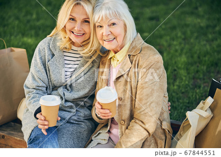 Cheerful smiling ladies are sitting in the park Cheerful smiling ladies are sitting in the park 67844551