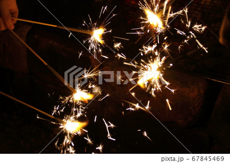 夏の夜に手持ち花火を楽しむ子供たちの写真素材