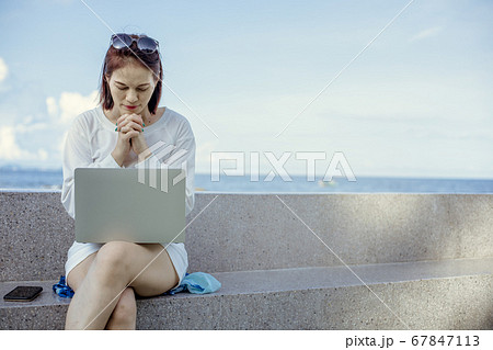 Asian female praying to god in front of a laptop Asian female praying to god in front of a laptop 67847113
