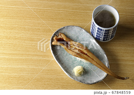 お皿の上に盛り付けられた炙り煮穴子の一本握りと熱々のお茶 67848559