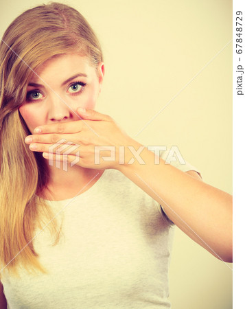 Ashamed woman having hand on mouth 67848729