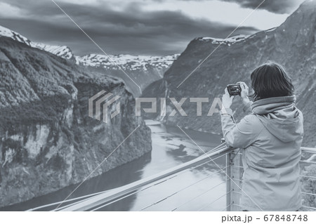 Tourist taking photo from Flydasjuvet viewpoint 67848748