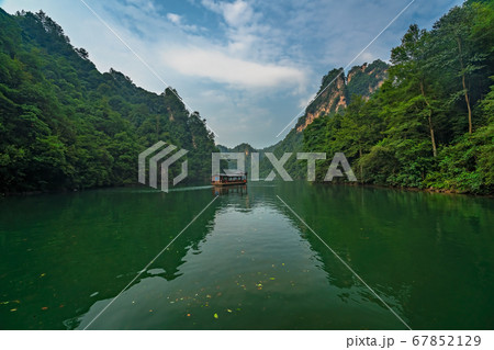 Tourist boat sailing among karst landscape on Tourist boat sailing among karst landscape on 67852129