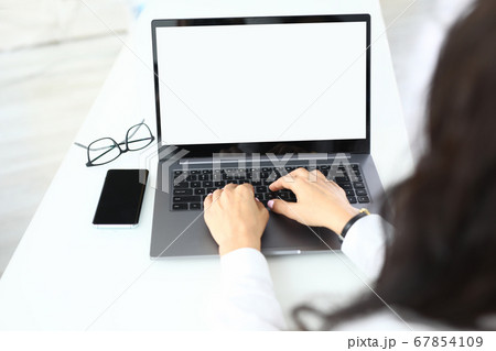 Woman works at laptop glasses lie beside closeup 67854109