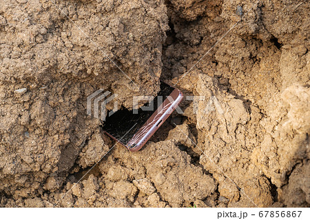 broken phone in the ground 67856867