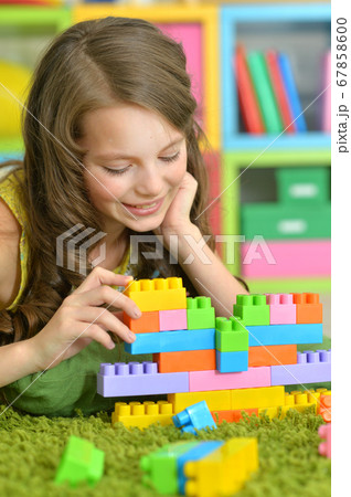 Portrait of girl playing with colorful plastic blocks Portrait of girl playing with colorful plastic blocks 67858600