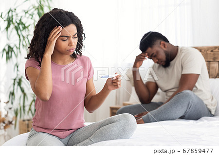 Worried black girl undergoing pregnancy test near boyfriend Worried black girl undergoing pregnancy test near boyfriend 67859477