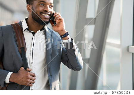 Black Businessman Talking On Cellphone Walking In Airport Terminal, Cropped Black Businessman Talking On Cellphone Walking In Airport Terminal, Cropped 67859533