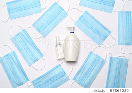 coronavirus COVID-19 pandemic concept - background made of antiviral surgical protective medical masks and alcohol hand sanitizer antiseptic for protection against corona virus 67862089