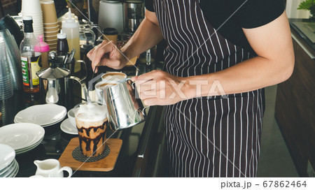 Barista is making drinks in the coffee shop. 67862464