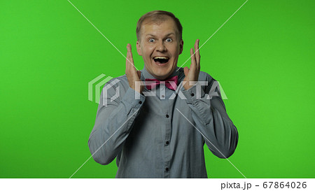 Man winning in lottery, raising hands for victory, opening his mouth in amazement, looking shocked Man winning in lottery, raising hands for victory, opening his mouth in amazement, looking shocked 67864026