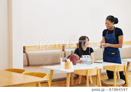 Waitres talking to customer 67864597